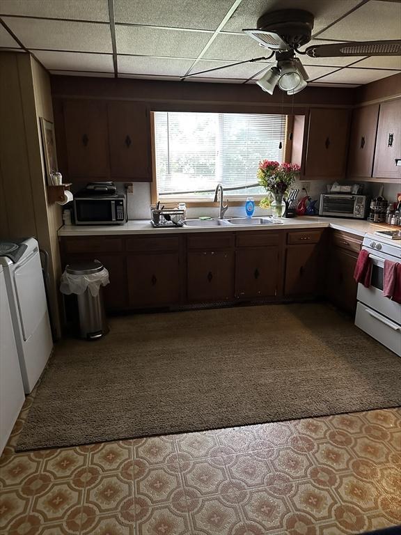 9 Coburn Ave, Worcester, MA 01604 - kitchen featuring white range with gas stovetop, a sink, washing machine and dryer, light countertops, and a ceiling fan