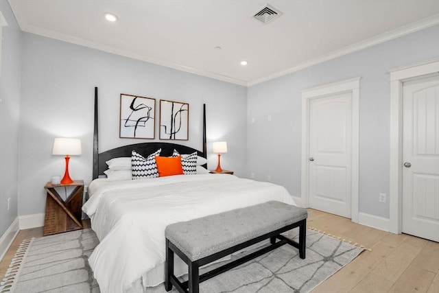 bedroom with ornamental molding, light wood finished floors, and baseboards