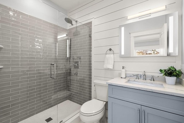 full bath featuring toilet, a stall shower, and vanity