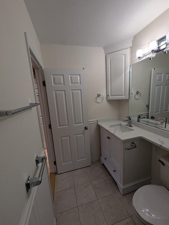 bathroom featuring vanity, tile patterned flooring, and toilet