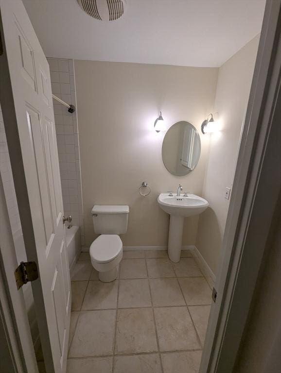 full bathroom with tiled shower / bath, sink, toilet, and tile patterned flooring