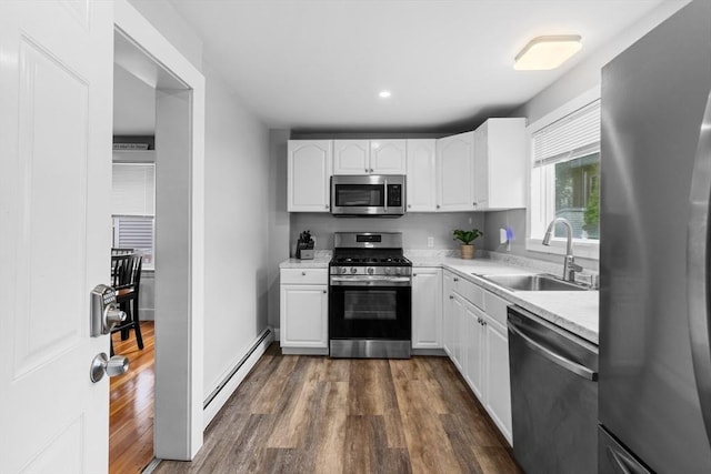 39-41 Ryan St, New Bedford, MA 02740 - kitchen featuring appliances with stainless steel finishes, a baseboard radiator, light countertops, dark wood-type flooring, and white cabinets