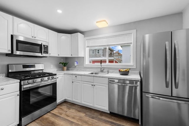 39-41 Ryan St, New Bedford, MA 02740 - kitchen featuring appliances with stainless steel finishes, white cabinets, light countertops, dark wood-style flooring, and recessed lighting