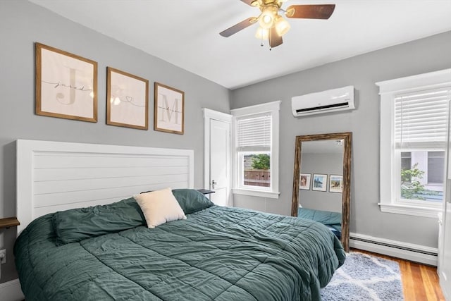 39-41 Ryan St, New Bedford, MA 02740 - bedroom with an AC wall unit, baseboard heating, wood finished floors, and a ceiling fan