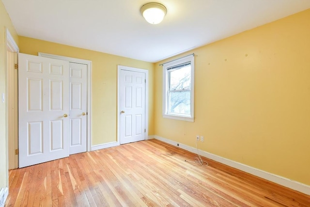 unfurnished bedroom featuring baseboards and light wood-style floors