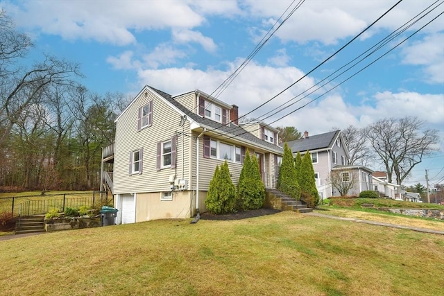 view of side of property with a yard, a garage, and fence