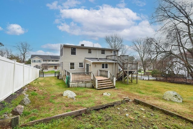 rear view of property featuring a yard, a fenced backyard, and a wooden deck