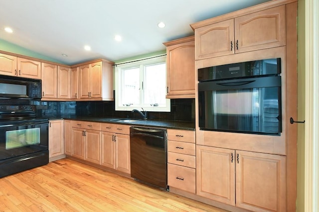 kitchen with light brown cabinetry and black appliances