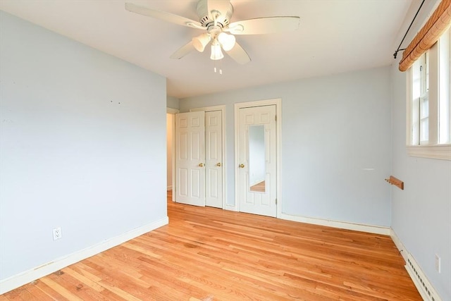 spare room featuring ceiling fan, light wood finished floors, and baseboards