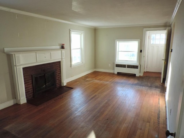 unfurnished living room with a fireplace, dark hardwood / wood-style flooring, radiator, and crown molding