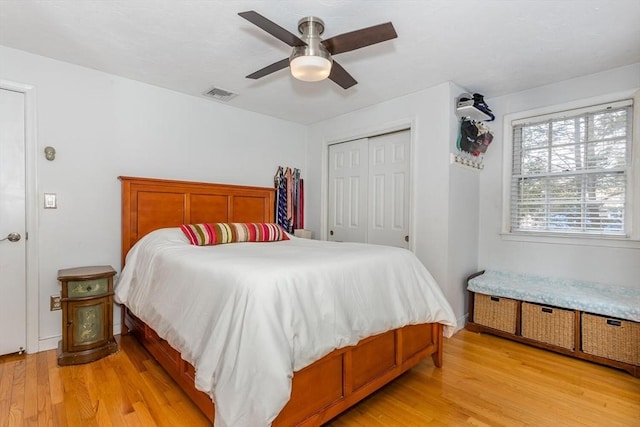 bedroom featuring a ceiling fan, a closet, visible vents, and light wood-style flooring