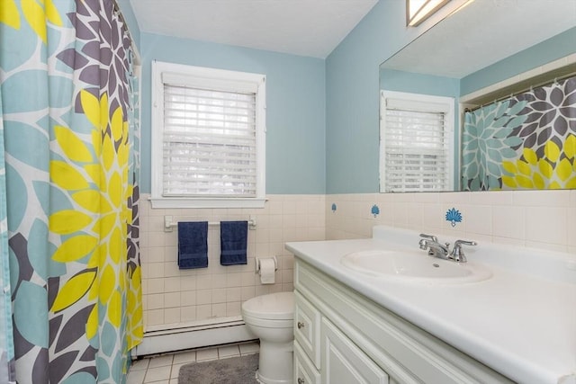 bathroom featuring toilet, tile patterned flooring, baseboard heating, vanity, and tile walls