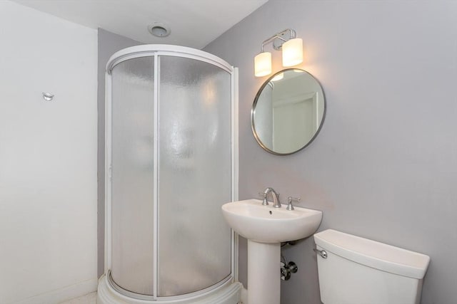 bathroom featuring a stall shower and toilet