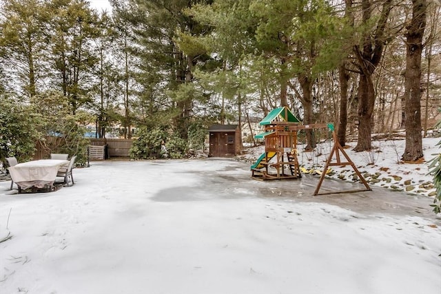 snow covered playground with fence and a playground