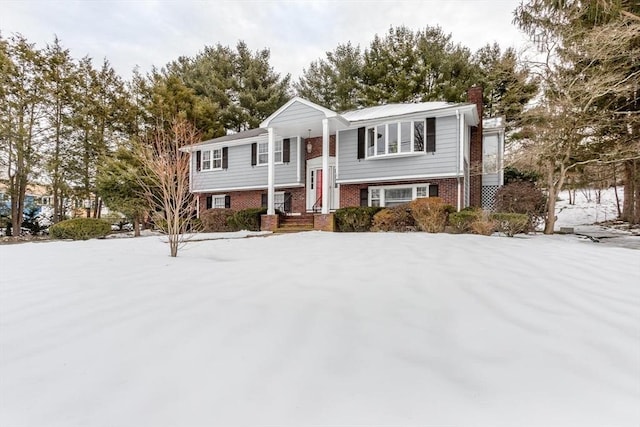 bi-level home with brick siding and a chimney