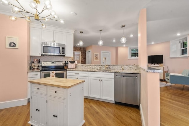 17 Gloucester St Unit A, Boston, MA 02115 - kitchen featuring appliances with stainless steel finishes, wood counters, light wood-type flooring, white cabinets, and recessed lighting
