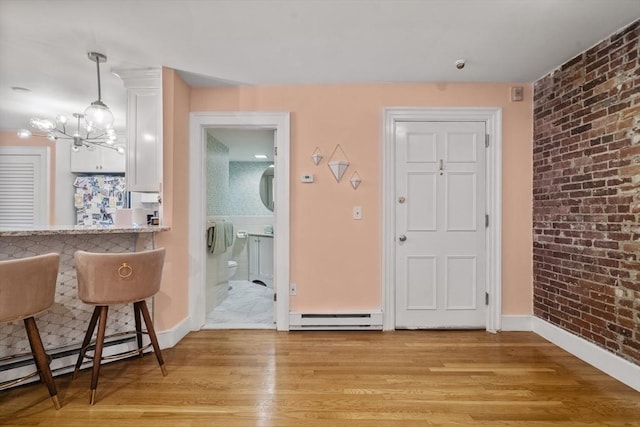 17 Gloucester St Unit A, Boston, MA 02115 - dining room featuring a baseboard heating unit, a chandelier, light wood-style floors, and brick wall