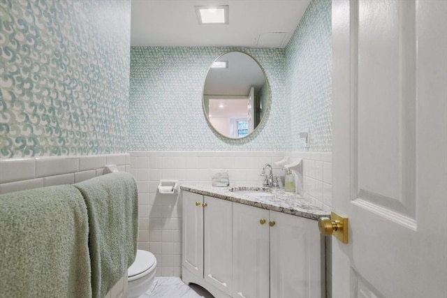 17 Gloucester St Unit A, Boston, MA 02115 - bathroom with wallpapered walls, tile walls, vanity, and wainscoting