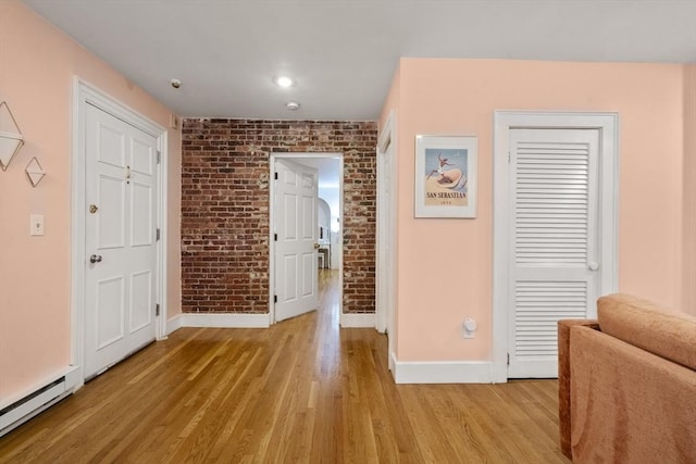 17 Gloucester St Unit A, Boston, MA 02115 - foyer with a baseboard radiator, brick wall, and light wood-style floors