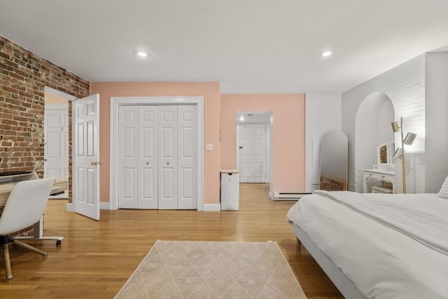 17 Gloucester St Unit A, Boston, MA 02115 - bedroom featuring brick wall, light wood-style floors, a baseboard radiator, a closet, and recessed lighting