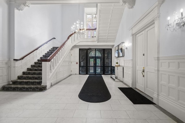 17 Gloucester St Unit A, Boston, MA 02115 - foyer with a chandelier, a high ceiling, a decorative wall, stairs, and a wainscoted wall