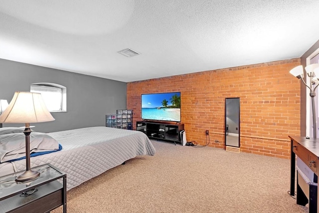 bedroom with visible vents, a textured ceiling, brick wall, and carpet