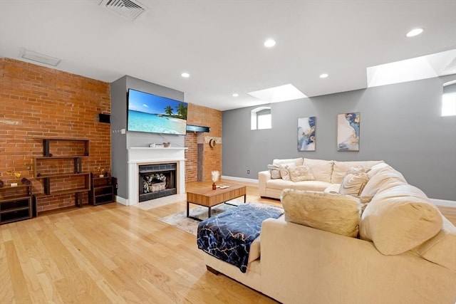 living room with visible vents, a fireplace with flush hearth, wood finished floors, recessed lighting, and baseboards