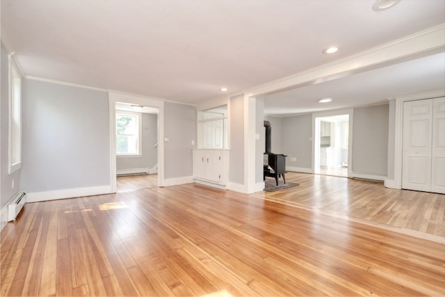 unfurnished living room featuring a baseboard radiator, a wood stove, light hardwood / wood-style floors, and crown molding