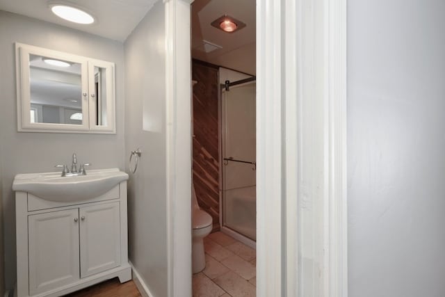 bathroom featuring walk in shower, tile patterned flooring, vanity, and toilet