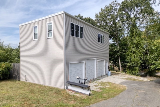 view of side of property featuring a lawn and a garage