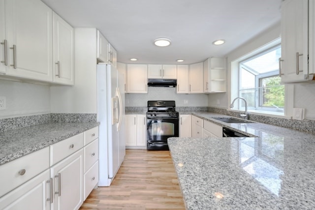 kitchen featuring white refrigerator with ice dispenser, black gas stove, white cabinets, and light stone countertops