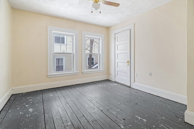 unfurnished room featuring dark wood-style floors, baseboards, and a ceiling fan