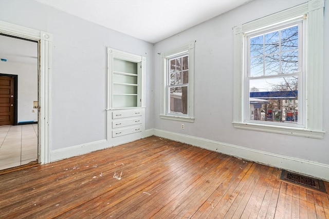 interior space featuring visible vents, baseboards, and wood finished floors