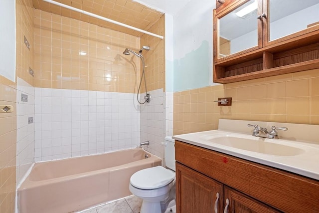 bathroom featuring tile walls, toilet, vanity,  shower combination, and tile patterned flooring