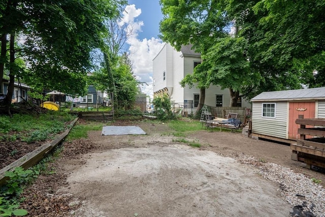 view of yard with an outbuilding, a storage unit, and fence