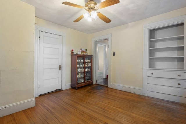 interior space featuring wood finished floors, a ceiling fan, and baseboards