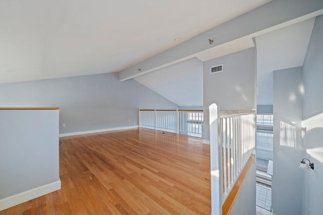 additional living space with lofted ceiling with beams and light hardwood / wood-style floors