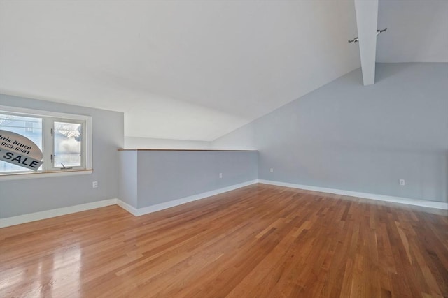 bonus room with lofted ceiling and light wood-type flooring