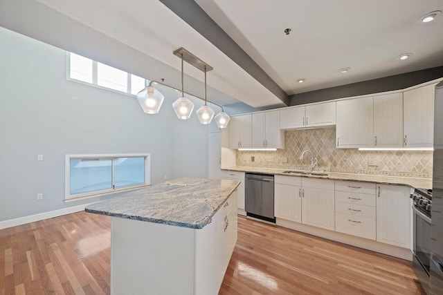 kitchen featuring white cabinetry, sink, decorative light fixtures, and stainless steel dishwasher