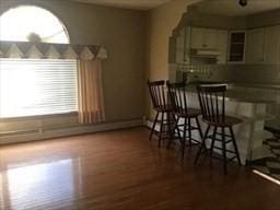 dining room with indoor bar and hardwood / wood-style flooring