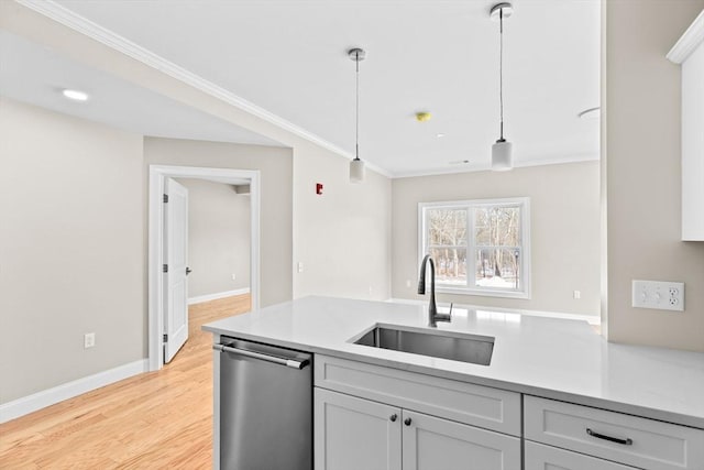 kitchen featuring a sink, light countertops, ornamental molding, stainless steel dishwasher, and decorative light fixtures