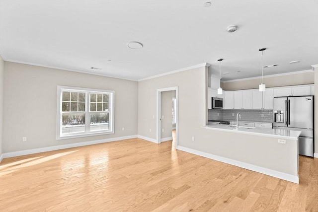 kitchen featuring tasteful backsplash, light wood-style flooring, stainless steel appliances, and light countertops