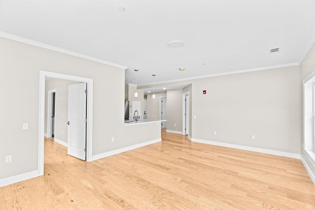 unfurnished living room with baseboards, light wood-type flooring, and crown molding