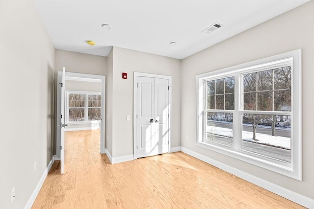 interior space featuring light wood-type flooring, baseboards, and visible vents