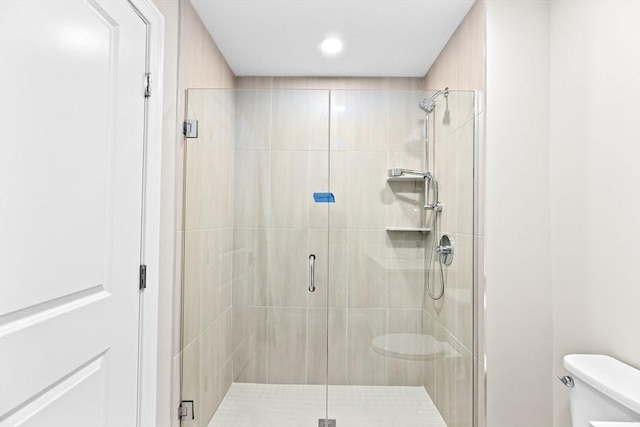 full bath featuring a shower stall and toilet