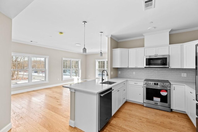 kitchen with tasteful backsplash, visible vents, appliances with stainless steel finishes, a sink, and a peninsula