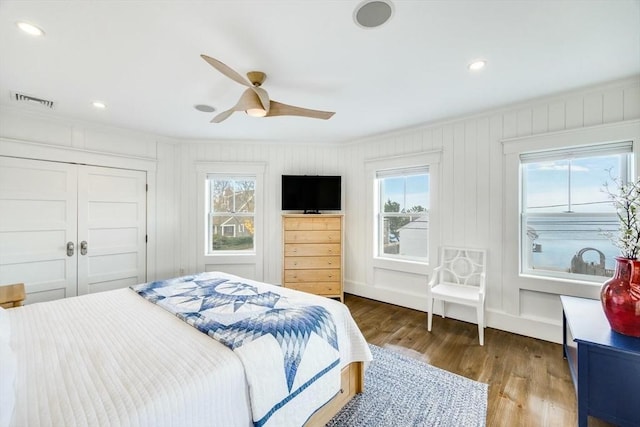 bedroom featuring ceiling fan, ornamental molding, dark wood-type flooring, and a closet