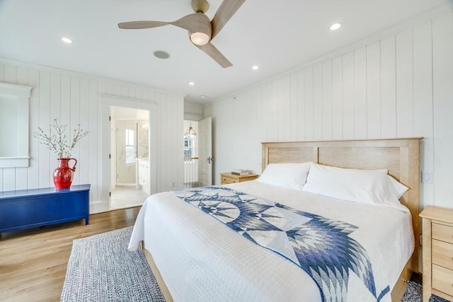 bedroom featuring light hardwood / wood-style flooring, ensuite bath, ceiling fan, and crown molding