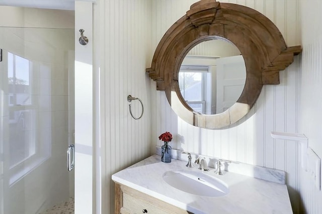 bathroom featuring a tile shower and vanity