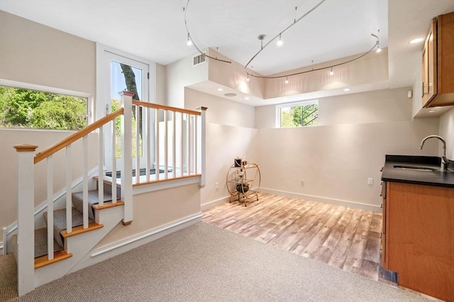 stairs with track lighting, baseboards, and wood finished floors